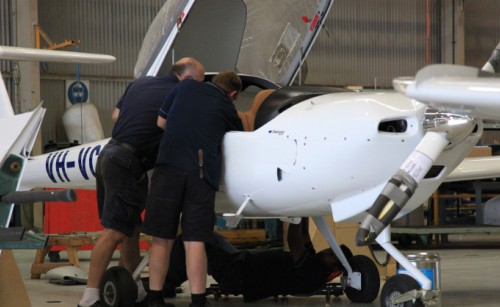 Two maintenance engineers examining the inside of an aeroplane